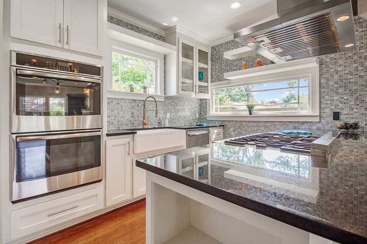 An image of a modern kitchen with sleek appliances, featuring a gas stove, refrigerator, and built-in microwave in Reston